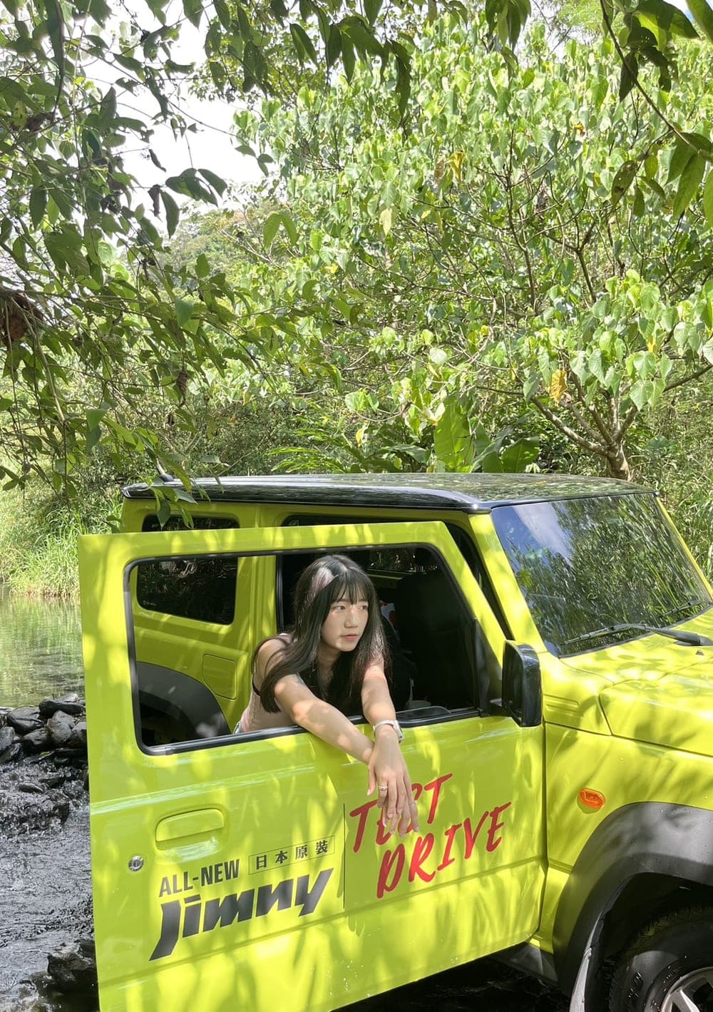 鈺漣倚在綠色 Jimny 車門旁，身後是戶外樹蔭